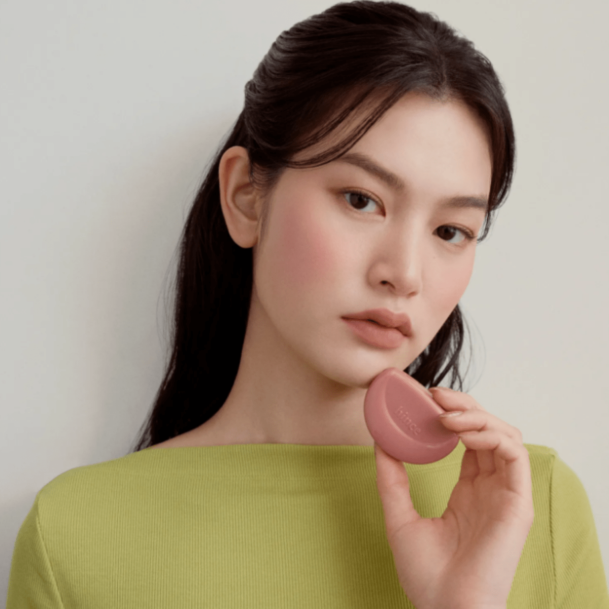 Hince Half-Moon Cheek Cream to Powder Blush in soft pink, showcasing the blush's compact and smooth, blended application on the cheek.