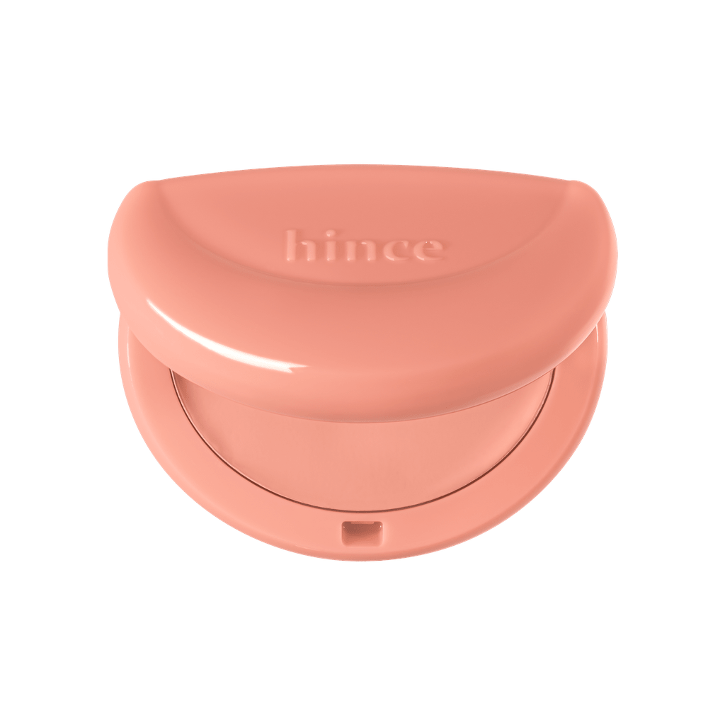 Hince Half-Moon Cheek Cream to Powder Blush in a compact with a half-moon shape, showcasing its soft pink color and smooth texture.