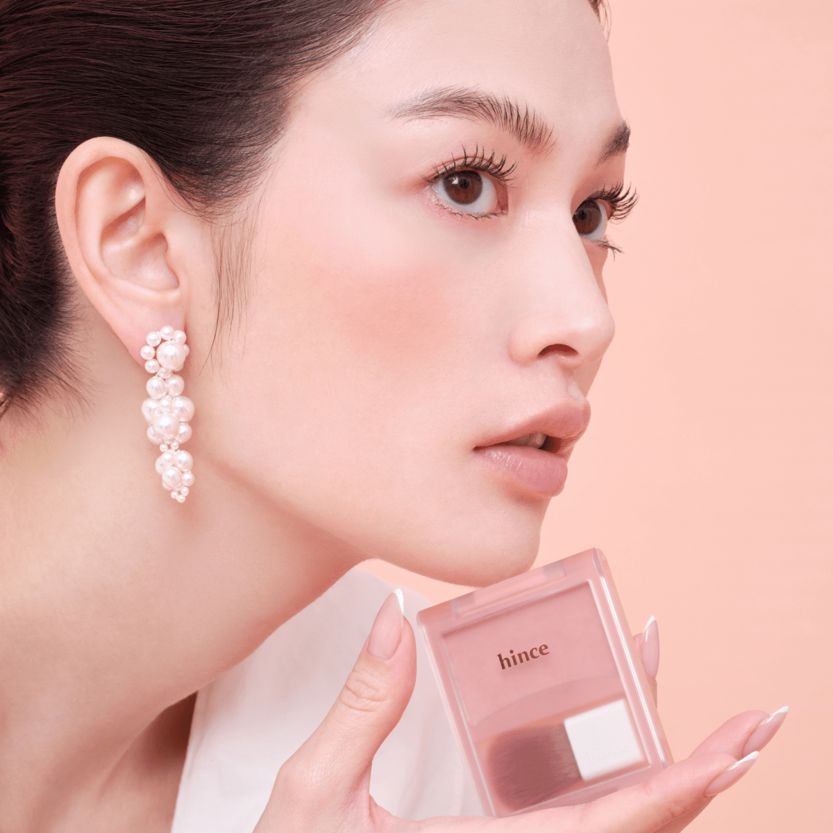 Hince Hug Layer Cheek Blush in a compact container, showing soft pink powder blush with a smooth texture and subtle sheen.