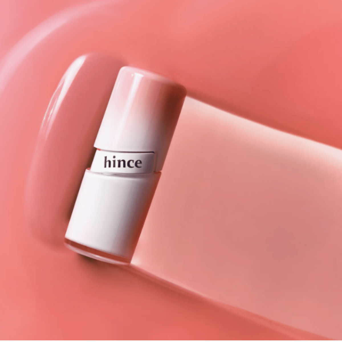 Hince Mirror Dew Gloss lip gloss tube with shiny, reflective packaging and clear applicator wand.
