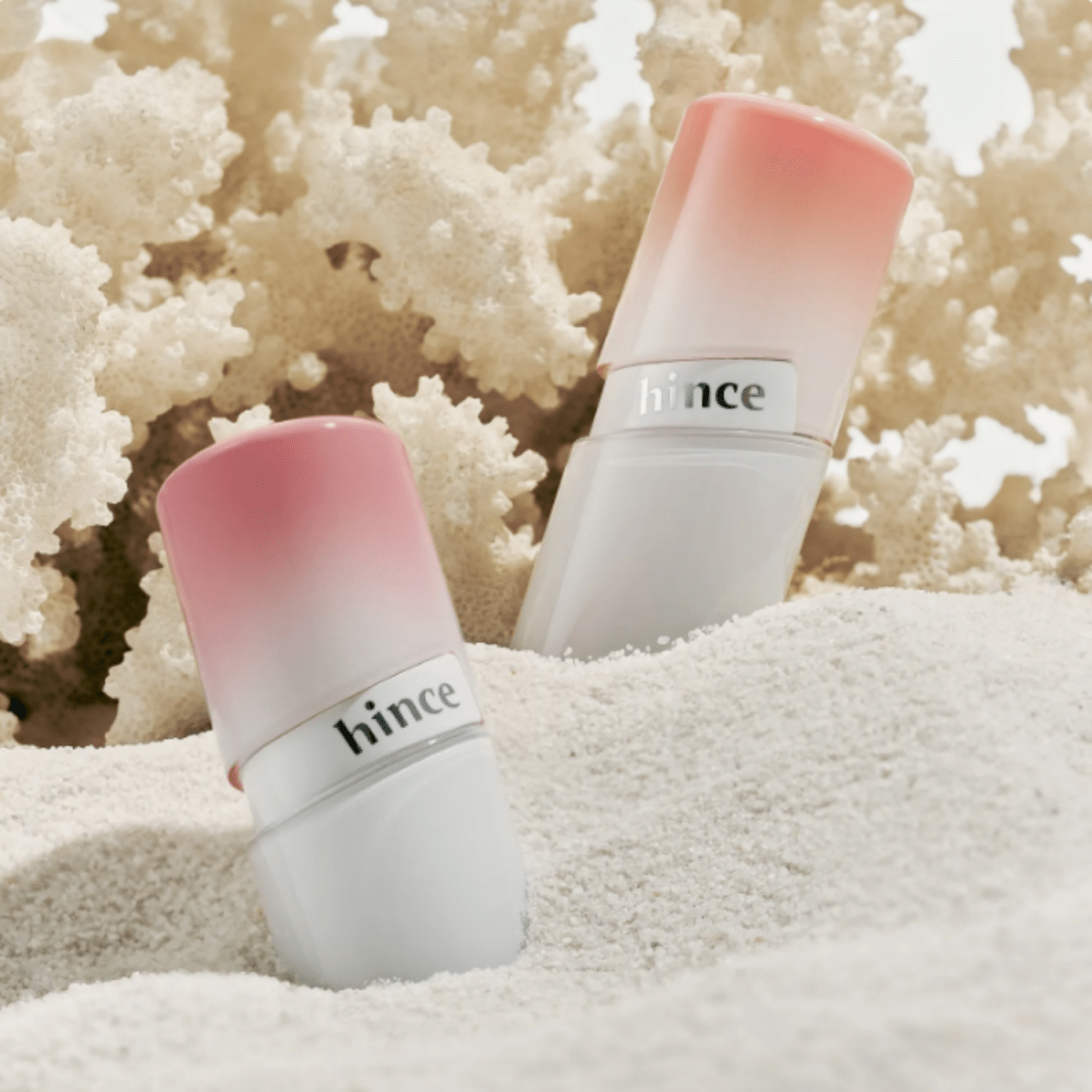 Hince Mirror Dew Gloss lip gloss in a sleek tube, showing its glossy, reflective finish and vibrant color for shiny lips.