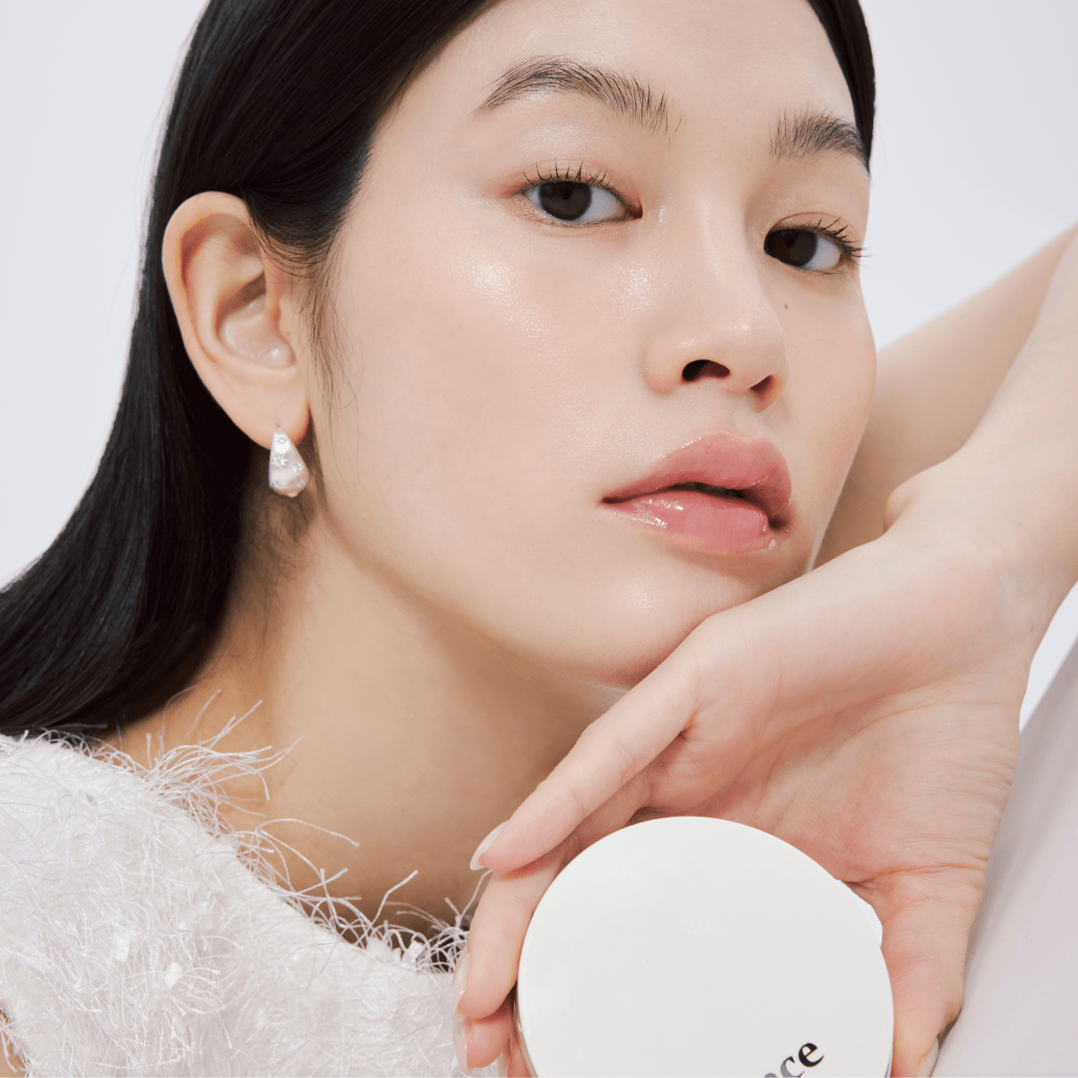 Hince Nu Glow White Cushion foundation in a compact with a reflective mirror, showcasing its sleek design and smooth surface.